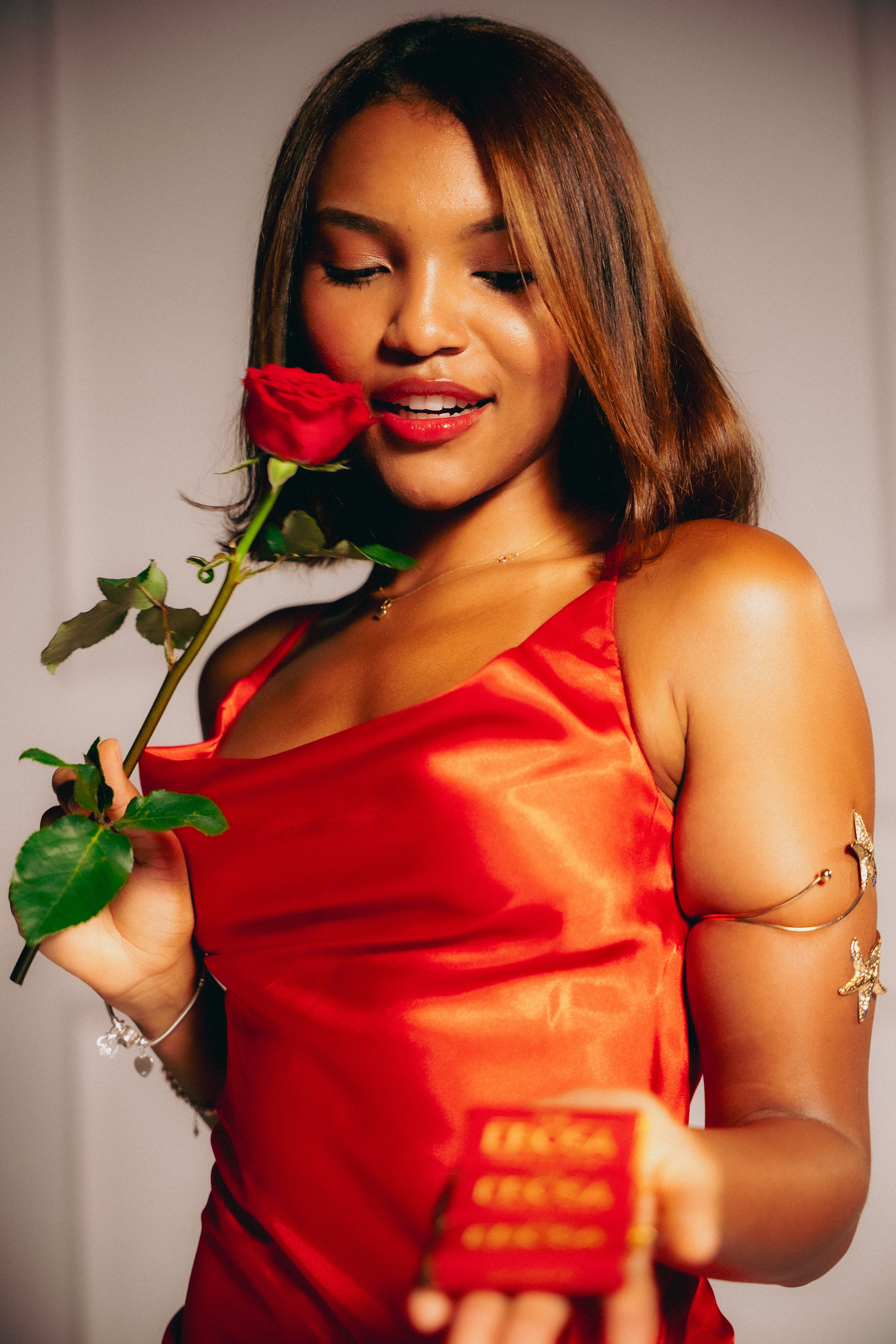 Woman in a red dress holding a red rose 